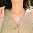 Load image into Gallery viewer, Collar de corazón grabado en plata usado por una modelo femenina.
