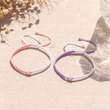 Load image into Gallery viewer, Grandmother and Granddaughter &quot;A Link That Can Never Be Undone&quot; Braided Bracelet lifestyle shot for pink and purple variants on canvas

