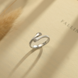 Load image into Gallery viewer, Silver Hug Ring placed at the top of a book

