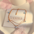 Load image into Gallery viewer, Blue Heart Evil Eye Gold Chain Ankle Bracelet on top of a SVANA Design card

