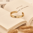 Load image into Gallery viewer, Gold Bangle Evil Eye Black Stones on a book
