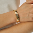 Load image into Gallery viewer, A model wearing Gold Bangle Evil Eye Black Stones
