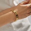 Load image into Gallery viewer, A model wearing an Evil Eye White Stones Gold Bangle
