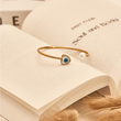 Load image into Gallery viewer, Heart &amp; Pearl Evil Eye Bangle on top of a book page
