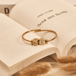 Load image into Gallery viewer, Initial Charm Evil Eye Bangle on top of a book page
