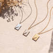 Load image into Gallery viewer, Personalized Love Letter Envelope Necklaces on a canvas background
