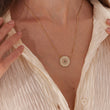 Load image into Gallery viewer, Round Jeweled Pink and Green Sunflower Gold Necklace worn by a female model on her neck
