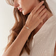 Load image into Gallery viewer, A model wearing Hamsa Hand Stoned Gold Chain Bracelet on her right wrist
