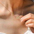 Load image into Gallery viewer, a model holding the Angel Number 000 Necklace while wearing it around her neck
