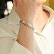 Load image into Gallery viewer, Meaningful message engraved in a bracelet with &quot;I love your&quot; silver cuff bracelet worn by a female model on her right wrist.
