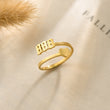 Load image into Gallery viewer, 888 Angel number gold ring placed on top of a piece of paper

