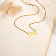 Load image into Gallery viewer, 111 angel number pendant gold necklace laid out
