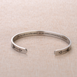 Load image into Gallery viewer, Sisters connected by the heart message printed on a cuff bracelet placed on top of a brown fabric
