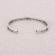 Load image into Gallery viewer, Inspiration message on silver plated bracelet &quot; A sister is God&#39;s way of making sure we never walk alone&quot; placed on top of a brown fabric
