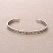 Load image into Gallery viewer, Memorial message for mother engraved on a silver bracelet placed on top of a brown fabric
