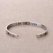 Load image into Gallery viewer, &quot;I am the storm&quot; bracelet placed on top of a piece of clothing
