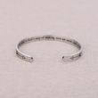 Load image into Gallery viewer, Inspiration message on bracelet &quot; A sister is God&#39;s way of making sure we never walk alone&quot; placed on top of a fabric
