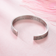 Load image into Gallery viewer, Silver cuff bracelet with &quot;I love you&quot; message placed over a pile of pinkish sand
