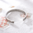 Load image into Gallery viewer, Silver cuff bracelet with &quot;I love you&quot; message placed over a pile of sand in a different angle
