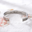 Load image into Gallery viewer, &quot;I am the storm&quot; silver cuff bracelet over a pile of sand and shells
