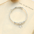 Load image into Gallery viewer, Dreamcatcher memorial bracelet on a book page
