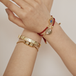 Load image into Gallery viewer, A model wearing Multicolored Charm Blue Evil Eye Red String bracelet with other evil eye bracelets
