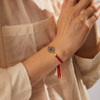 Load image into Gallery viewer, A model wearing a multicolored evil eye red string bracelet
