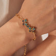 Load image into Gallery viewer, Multicolored twin butterfly charm gold chain bracelet in a white background being worn by a model on her right wrist
