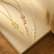 Load image into Gallery viewer, Personalized Birth Flower Necklaces of a page of an open book

