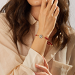 Load image into Gallery viewer, A model wearing a Round Charm Black Evil Eye Red String Bracelet
