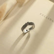 Load image into Gallery viewer, Angel Wing Personalized Pet Memorial Ring on a book page
