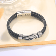 Load image into Gallery viewer, Mother and Daughter Forever Linked Together&quot; Braided Leather Bracelet placed on a blank page of an open book
