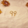 Load image into Gallery viewer, Jeweled Cross Gold Earrings placed on top of a piece of cotton fabric
