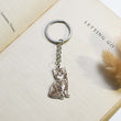 Load image into Gallery viewer, silver cat Personalized Pet Sketch Keychain on a page of an open book
