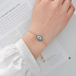 Load image into Gallery viewer, Gold Chain Wide Blue Evil Eye Bracelet worn by a model
