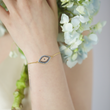 Load image into Gallery viewer, Gold Chain Wide Blue Evil Eye Bracelet worn by a model on her left wrist
