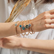 Load image into Gallery viewer, A model wearing Round Shaped Blue Evil Eye Beaded Bangle and other evil eye bangles
