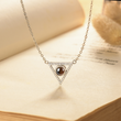Load image into Gallery viewer, To My Wife, Triangle Projection Necklace hanging on top of an open book

