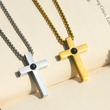 Load image into Gallery viewer, Personalized Memorial Cross Projection Necklace placed at the edge of a book page
