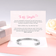 Load image into Gallery viewer, A silver bangle bracelet with a printed message &quot;God Is Within Her - Psalm 46:5&quot; placed on top of gift message card

