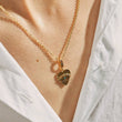 Load image into Gallery viewer, A model wearing Heart Shaped Evil Eye Gold Tone Necklace
