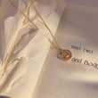 Load image into Gallery viewer, Ancient Ray Evil Eye Medallion Necklace on top of a book page
