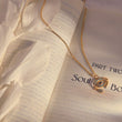 Load image into Gallery viewer, Eye of Horus Gold Chain Evil Eye Necklace on top of a book page
