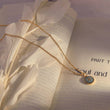 Load image into Gallery viewer, Ancient Protector Evil Eye Gold Tone Necklace on top of a book page
