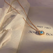 Load image into Gallery viewer, Blue Evil Eye Gold Chain Necklace on top of a book page 
