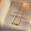 Load image into Gallery viewer, Infinity Evil Eye Gold Chain Necklace on top of a book page
